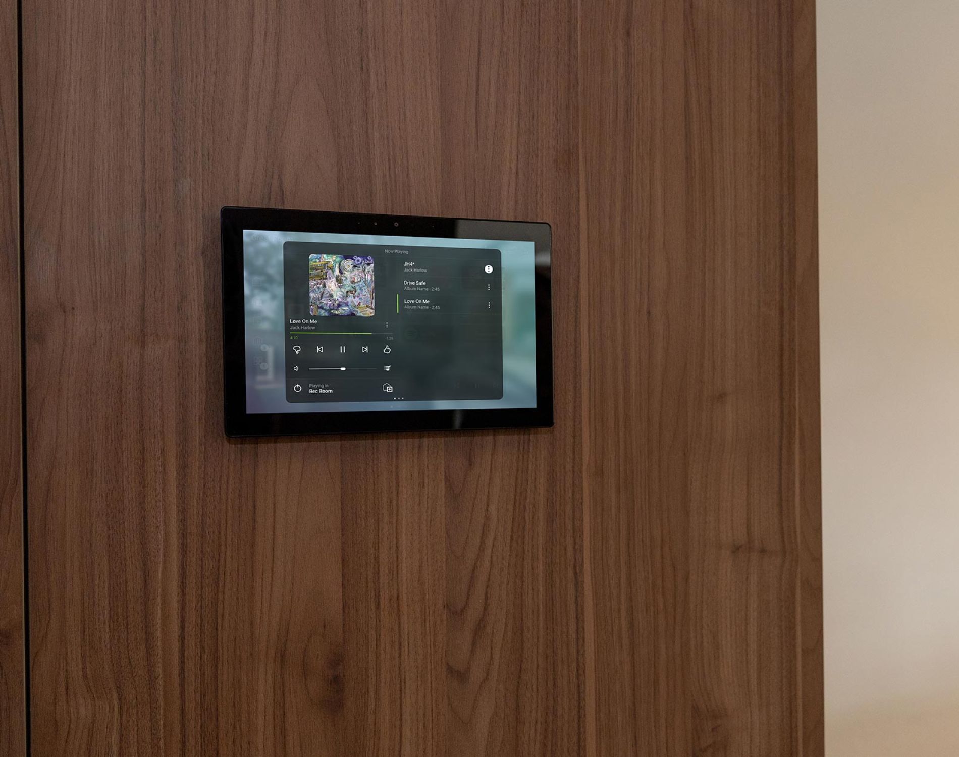 Wall-mounted smart home touchscreen panel displaying a music player interface